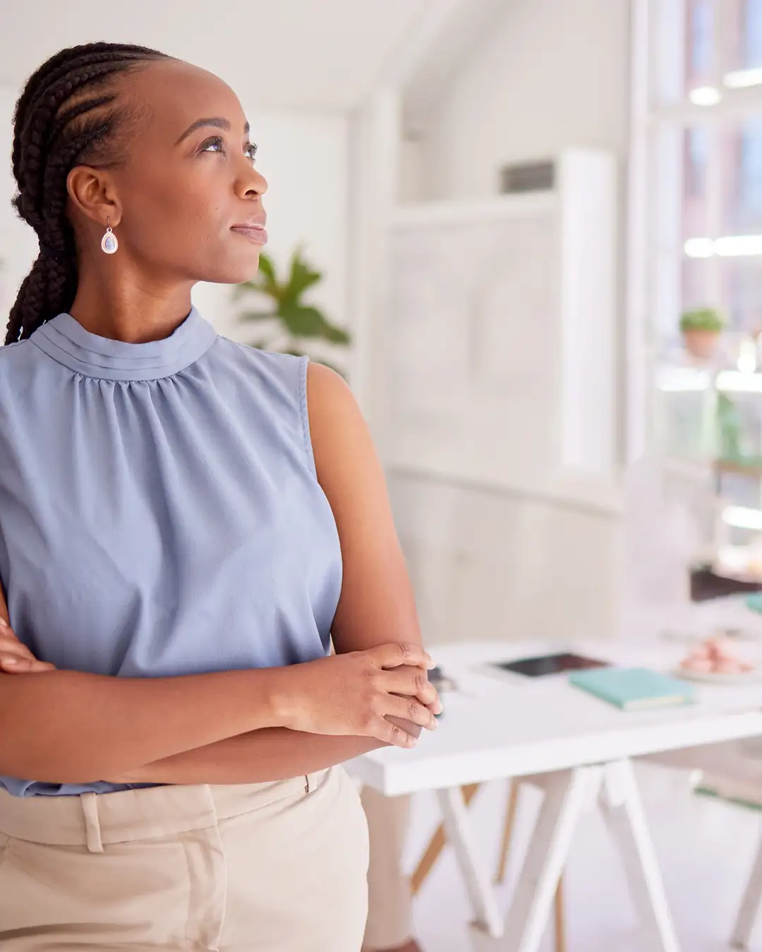 A professional woman in a quiet reflective moment, sitting near a window